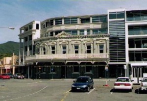 Blurry image of Oxley's Hotel Facade, Picton, with cars in parking lot in foreground.