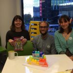 3 people with Lego in front of them on a table