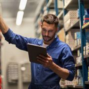 Man using tablet in a warehouse.